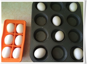 Eggs distributed in a muffin tin (with water) and in a silicone tray, prior to baking.